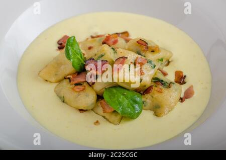Gnocchetti di spinaci con salsa di Parmigiano e rabboccato con pancetta, pulire serve, ingredienti in background Foto Stock