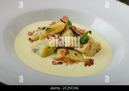 Gnocchetti di spinaci con salsa di Parmigiano e rabboccato con pancetta, pulire serve, ingredienti in background Foto Stock