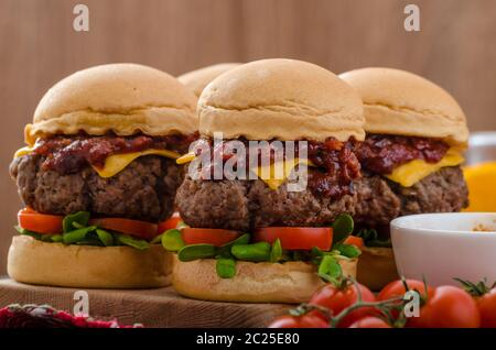 Carni bovine i cursori con fatti in casa salsa barbecue, cheddar, pomodorini e microgreens Foto Stock