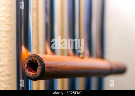Le campane tubolari in metallo con un tubo di bambù pendono sulla parete e creano la musica del vento. Foto Stock