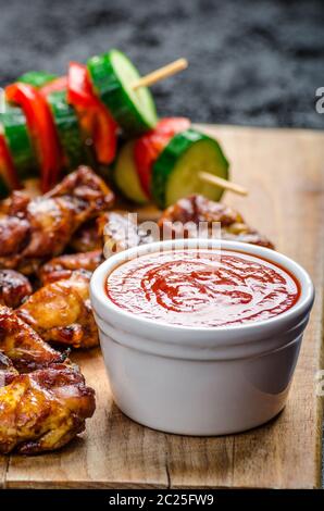 Sticky pollo con red hot dip e spiedini vegetariani Foto Stock