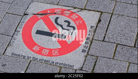 Cartello per non fumatori sul marciapiede a Shinjuku, Tokyo, Giappone Foto Stock