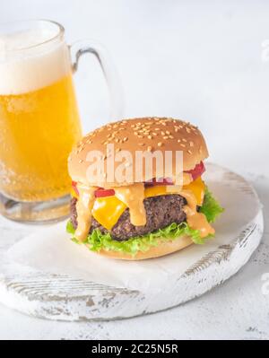 Hamburger con la tazza di birra sul pannello di legno Foto Stock