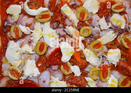 Preparazione di alimenti italiani condimenti non cotti su pasta cruda. La pizza fatta in casa è un modo per utilizzare le verdure rimanenti pezzi di carne o pesce che possono essere triturato. Foto Stock