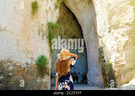 Bella donna entra nell'Orecchio di Dionisio (Orecchio di Dionisio) di Siracusa, Sicilia, Italia Foto Stock
