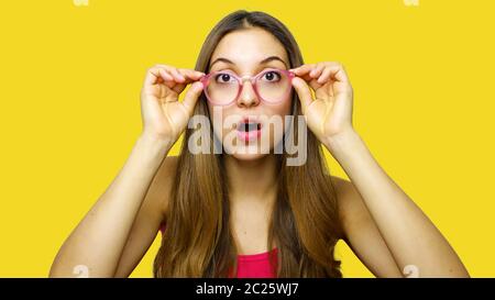 Wow! Non ti credo! Close up ritratto di scioccati stupiti donna con la bocca aperta e gli occhi grandi, lei sta toccando il suo occhiali. Foto Stock