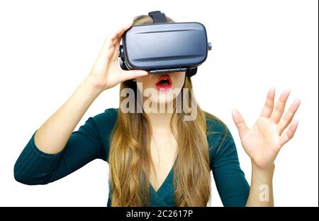 Stupiti giovane donna toccando l'aria durante l'esperienza di VR Foto Stock