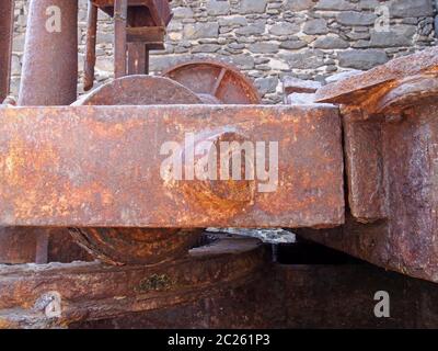 Primo piano di vecchio meccanismo di gru arrugginito nelle vecchie banchine di carbone a funchal Madeira contro un muro di pietra Foto Stock