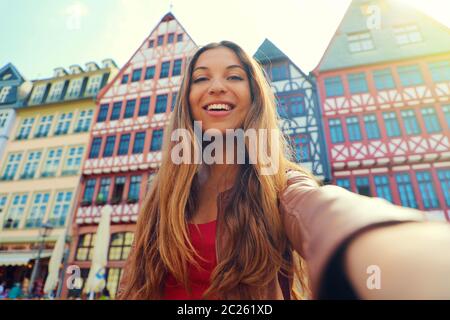 Bella donna sorridente prendere ritratto di auto in Piazza Romerberg a Francoforte, Germania Foto Stock