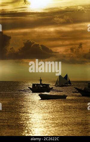 Philippine tradizionali barche sul tramonto. Isola Boracay Foto Stock