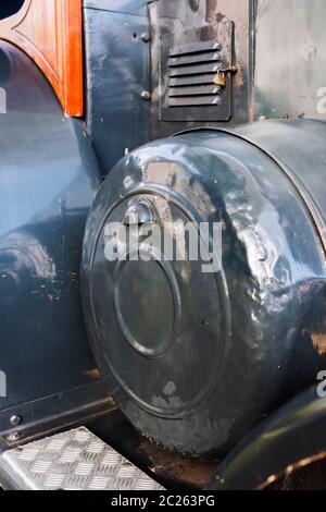 Coperchio del volano ammaccato su un vecchio trattore verniciato grigio di produzione tedesca. Foto Stock