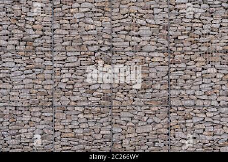 Grande gabione a più piani con una forma leggermente ricurva, riempito con pietre naturali grigie Foto Stock