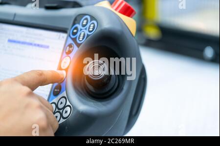 Ingegnere punto a mano in corrispondenza del joystick del robot di controllo in fabbrica. Utilizzare robot intelligenti nel settore manifatturiero per l industria 4.0 e concetto tecnologico. Foto Stock