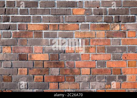 Sfondo di un muro di mattoni con diverse sfumature di rosso Foto Stock