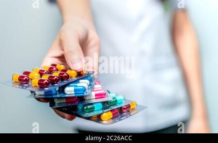 Farmacista o medico che tiene a mano la confezione di pillole di capsule di antibiotici e che dà paziente o persone. Abuso di antibiotici. Resistenza antimicrobica al farmaco Foto Stock
