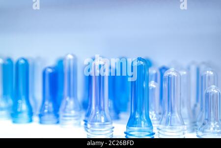 Preforme di bottiglie di PET prima di stampaggio per soffiatura, il riempimento e la procedura di etichettatura. Blue preforme di bottiglie di PET per l'industria delle bevande. Il materiale grezzo per la bottiglia di PET wit Foto Stock