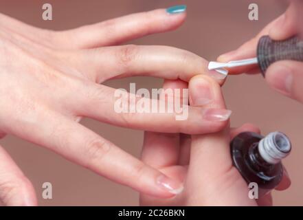 La donna la ricezione di unghie manicure dal servizio professionale a manicurist manicure. Estetista Verniciatura colore bianco chiodo a chiodo e spa salone. Fo Foto Stock