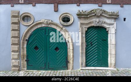 Antica facciata con due porte con il barocco portale in pietra Foto Stock