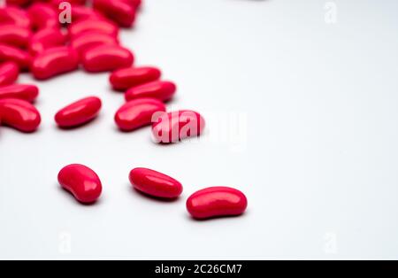 Rosso forma di rene di zucchero compressa rivestita pillole isolato su sfondo bianco con copia spazio per il testo. Foto Stock