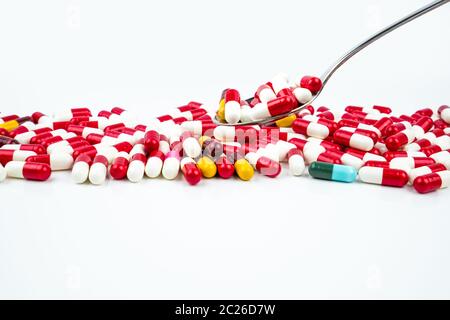 Le capsule di antibiotici pillole in acciaio inox cucchiaio su sfondo bianco con copia spazio. La resistenza al farmaco concetto. Antibiotici il consumo di stupefacenti con ragionevole Foto Stock