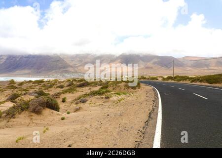 Bellissima vista del vuoto strada asfaltata che curva nel deserto di Lanzarote, Isole Canarie Foto Stock