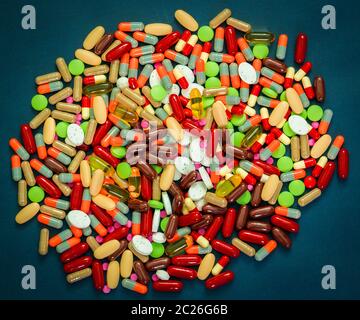 Pila di coloratissimi compresse e capsule pillole su sfondo blu. La resistenza agli antibiotici e il consumo di stupefacenti con il concetto di ragionevole. Industria farmaceutica. G Foto Stock