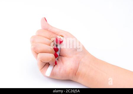 Donna adulta mano con unghie rosse sigaretta schiacciata su sfondo bianco. Smettere di fumare concetto. 31 Maggio: celebra la Giornata Mondiale senza tabacco. Donna mano distruggendo cigare Foto Stock