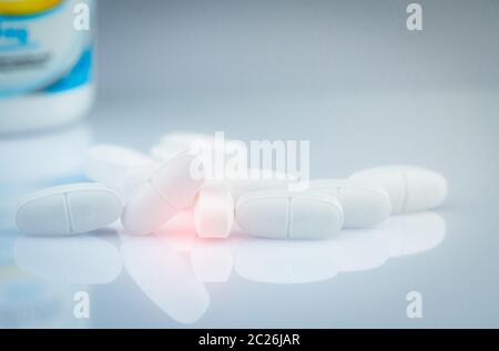 Compresse di calcio per i bambini o la donna incinta. Compresse bianche pillole su sfocato flacone di farmaco sfondo. Vitamine e concetto di supplemento. Prodotti farmaceutici Foto Stock