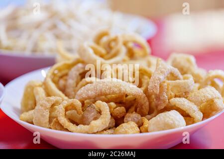 Mucchio di spuntino di maiale fritto o cotto, scorza di maiale, graffiatura di maiale o gramolatura di maiale su piatto bianco. Foto Stock