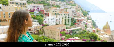 Ritratto di una romantica dolce donna in abito verde guardando a Positano villaggio da un terrazzo, Costiera Amalfitana, Italia. Panoramica vista banner. Foto Stock