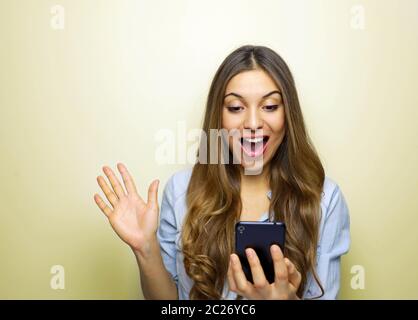 Overjoyed felice femmina eccitato lieti di ricevere un messaggio di testo per informare circa lo stipendio, esulta la buona novella, guarda il telefono cellulare e i gesti da attivamente Foto Stock