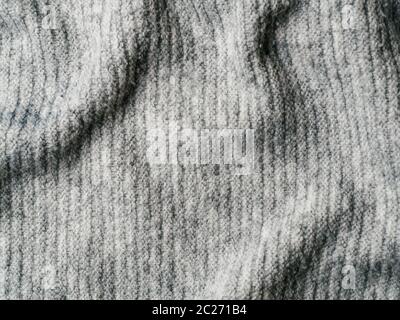 Maglione grigio tessuto texture. Abbigliamento maglione sfondo con pieghe Foto Stock
