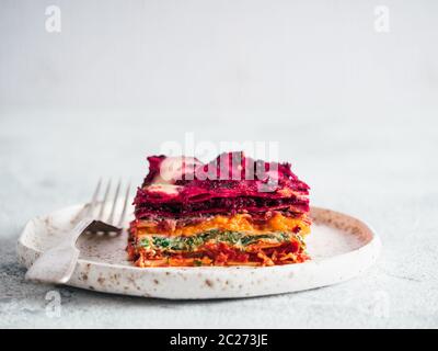 Ortaggio pranzo Rainbow lasagne sulla piastra di artigianato.idee e ricette per vegetariani sani per pranzo o cena. Lasagne con barbabietola,zucca,funghi,rico Foto Stock