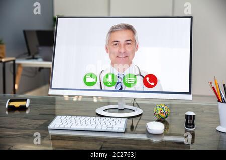 Medico sorridere mentre le videoconferenze su Computer in ospedale Foto Stock
