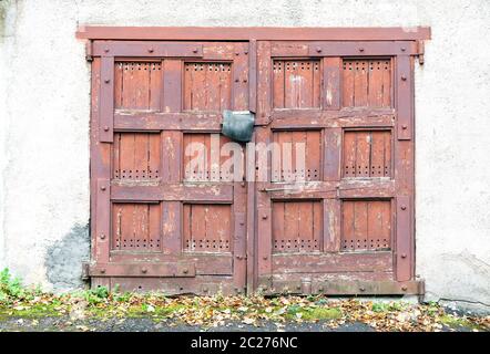 Vecchio abbandonato garage in legno porte, chiusura porte spiovente vista frontale Foto Stock