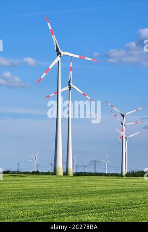 Le turbine eoliche nel verde di un campo di mais visto in Germania Foto Stock