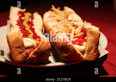 Big hot dog con salse e patate fritte Foto Stock