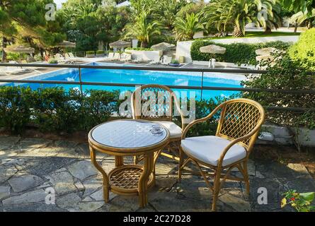 tavolo e sedie per il riposo che si affaccia sulla piscina Foto Stock