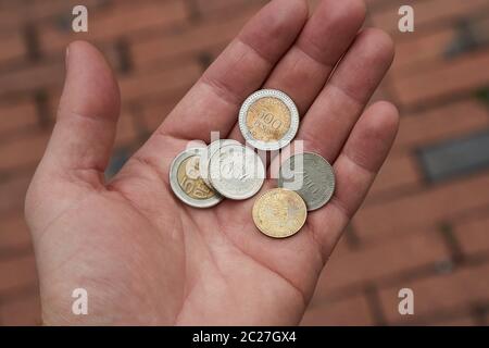 Monete in mano umana, pesos colombiani Foto Stock