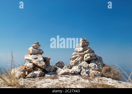 Due torri di pietra - pile di pietre zen su un cielo blu sullo sfondo Foto Stock