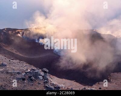 Fumoso scenario del cratere di vulcano Stromboli vicino la Sicilia al tempo di sera Foto Stock