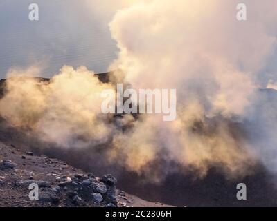 Fumoso scenario del cratere di vulcano Stromboli vicino la Sicilia al tempo di sera Foto Stock