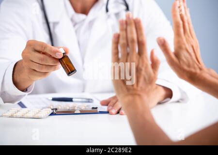 Close-up di mano di una persona che rifiuta di utilizzare farmaci detenute dal medico Foto Stock
