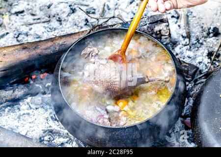 La zuppa viene cucinata in una pentola turistica sul fuoco Foto Stock