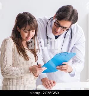 Medico spiegando al giovane madre Foto Stock