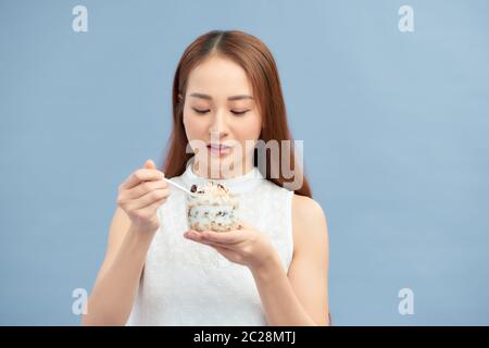 Ritratto di bella ragazza sorridente in forma con yogurt, uvetta e farinata d'avena. Foto Stock