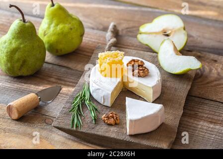 Formaggio Camembert con pere e noci sul pannello di legno Foto Stock