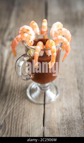 Gamberi cotti con salsa di pomodoro sul tavolo di legno Foto Stock