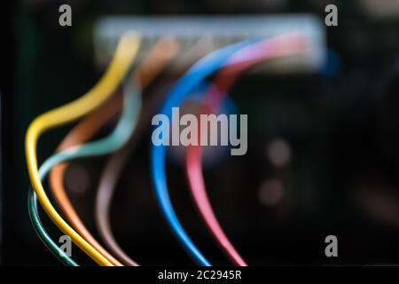 Cavi di alimentazione colorati provenienti da un trasformatore. Mettere a fuoco sui fili verdi e verdi a sinistra. Foto Stock