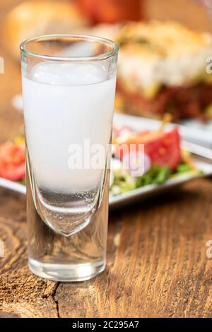 Ouzo greco con la moussaka su legno Foto Stock